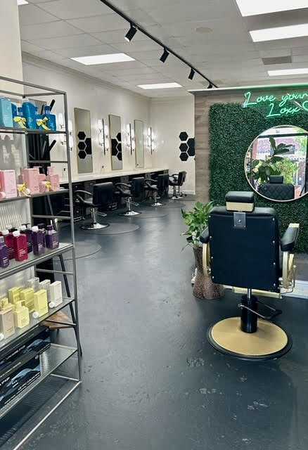 Chic hair salon with modern decor, neon sign, styling chairs, and shelves of products.